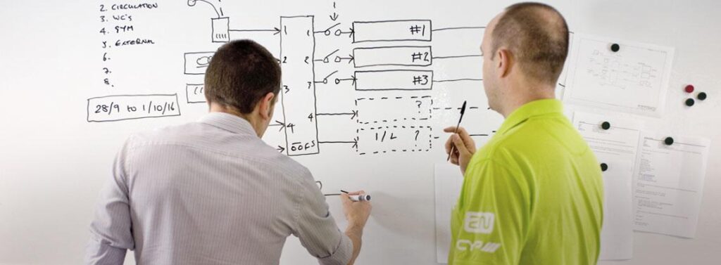 CIE engineers planning a system on a whiteboard