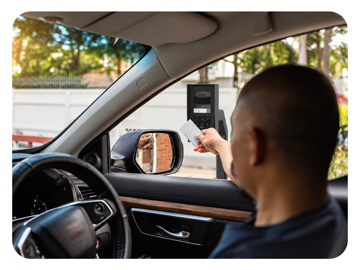 Driver using a contactless access card at a vehicle entry intercom and keypad from inside a car