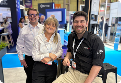 CIE Group team members smiling together at a busy trade show stand