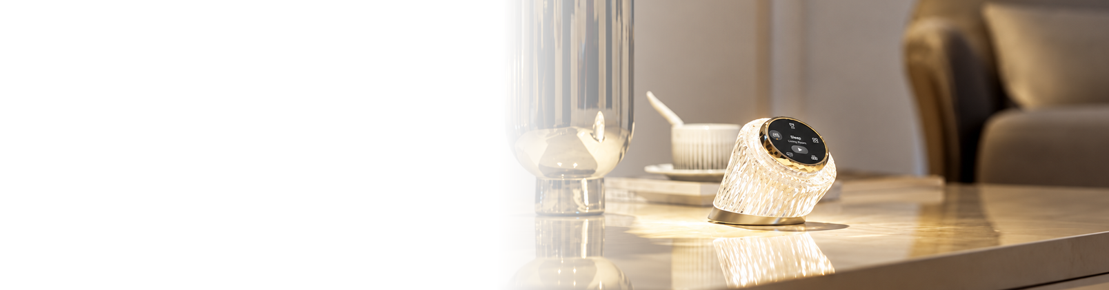 Crystal-style smart home control hub with touchscreen display and illuminated base positioned on a modern tabletop