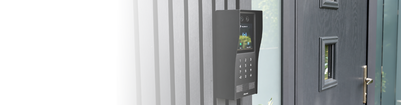 Akuvox smart video intercom installed beside a modern residential entrance, featuring dual cameras, touchscreen and keypad access