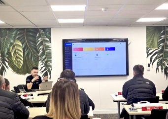 Akuvox training session with attendees watching a presentation of the property management platform on a large display